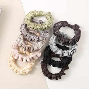 Detailed view of 7-pack pleated satin scrunchies with elegant resin buckle accents