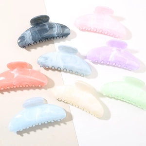 Flat lay of floral acetate hair claws in various gradient marble patterns and pastel colors
