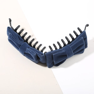 Détail d'une pince banane en velours bleu marine avec poignée en plastique sûre