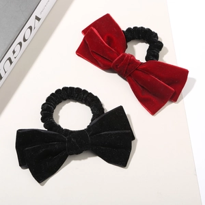 Détail de chouchous à nœuds en velours rouge et noir à texture douce sur un magazine