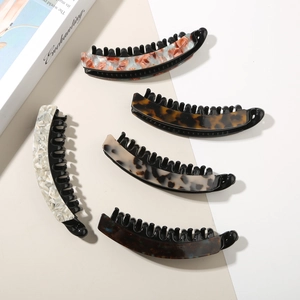 Close-up of five colorful acetate banana hair clips in leopard and marble patterns