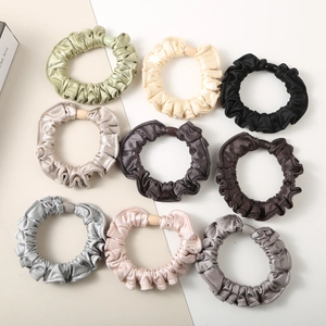 Detail view of nine-piece satin scrunchies set in various colors with silky texture