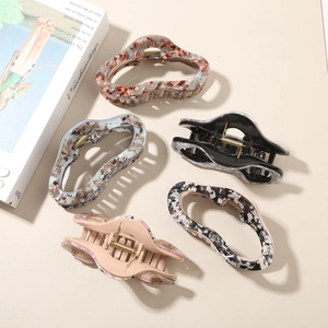 Detailed view of five marble and tortoiseshell acetate hair claws with strong metal springs