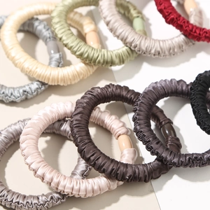 Elastic satin scrunchies set in various colors like beige green and burgundy for hair ties
