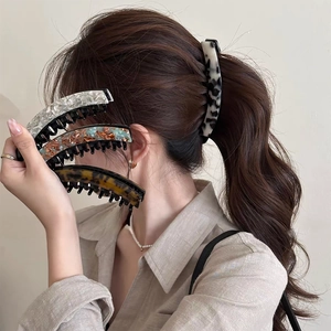 Detail of diverse acetate leopard print banana hair clips shown on a model