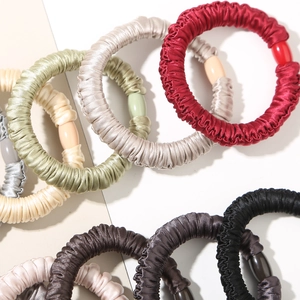 Elastic satin scrunchies with pleated texture and decorative beads in various colors