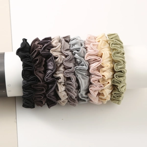 7-piece set of elegant satin scrunchies in assorted colors on a white display stand