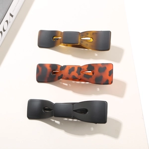 Ensemble détaillé de trois barrettes à nœuds en acétate noir, écaille et ambre fini