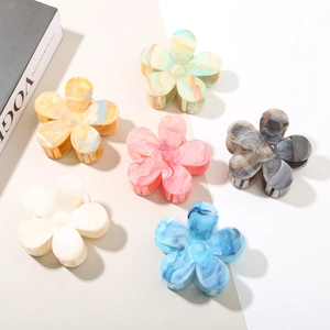 Flat lay of six floral acetate hair claws with marble texture in diverse pastel colors