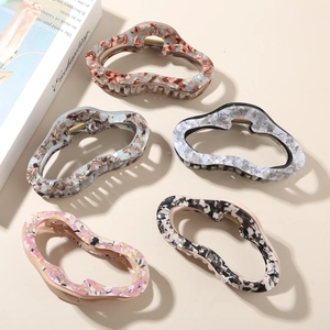 Flat lay of five acetate cloud hair claws with marble texture in various colors