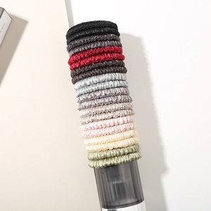Close-up of silk scrunchies with pleated elastic texture stacked on a display stand