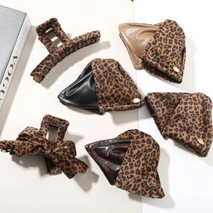 Detail of leopard print hair claw clips and leather patchwork hairpins with gold accents