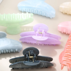 Elegant semi-round acetate hair claws in pastel marble colors with strong metal springs