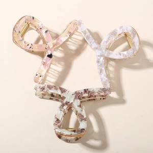 Macro detail of three acetate hair claws featuring floral and marble patterns