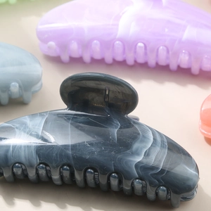 Detailed view of a large dark grey marble texture hair claw clip made of acetate material
