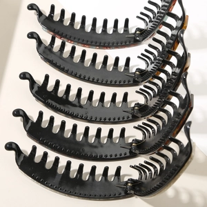 Close-up of five colorful acetate banana hair clips with leopard patterns and metal springs