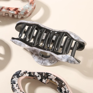 Detailed macro of a large marble acetate hair claw clip with strong metal spring
