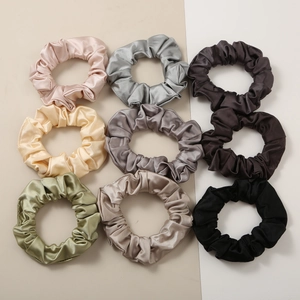 Macro view of 9-piece satin scrunchie set in various colors with elegant pleated silk texture