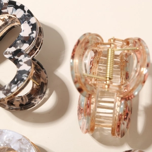 Detail shot of tortoiseshell acetate hair claw clip with black and white marble patterns