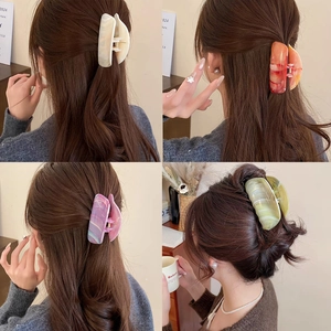 Detail view of large marble texture hair claws in four colors for thick hair