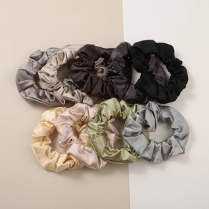Flat lay of 7-piece satin hair scrunchie set in various elegant colors with silky texture