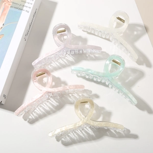 Detail of five marble texture claw clips in pastel colors with strong metal springs