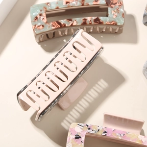 Détail de pinces à cheveux rectangulaires en acétate avec texture marbrée et ressort