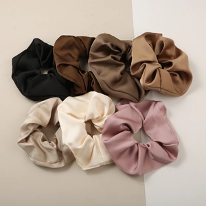 Detailed set of seven satin scrunchies in diverse earth tones with smooth texture