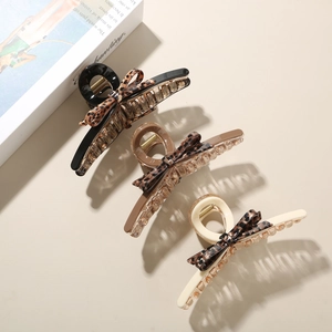Close-up of leopard print bow hair claws in black, dark brown, and cream white colors