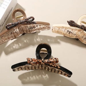 Three large acetate bow hair claws in dark brown, beige, and black for thick hair styling