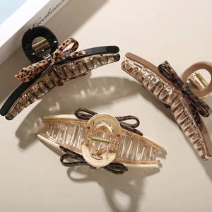Three acetate hair claws with leopard print bows in black, coffee, and beige colors