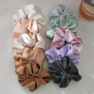 Set of ten glossy satin scrunchies in various colors displayed on a neutral surface