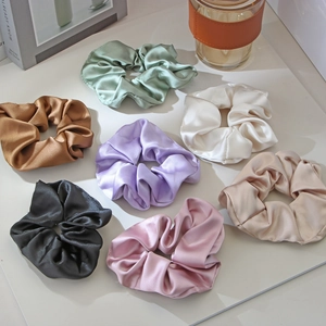 Detail view of premium satin scrunchies in seven elegant colors for daily hairstyles