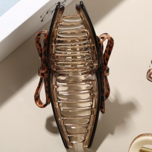 Macro view of leopard print bow hair claw with amber acetate teeth and sturdy metal spring
