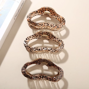 Vertical display of three coffee leopard print acetate hair claws with glossy finish