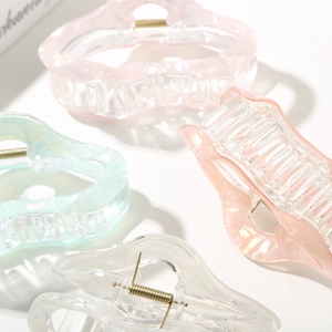 Detail of wavy jelly hair claws with iridescent pearl finish and metal spring clips