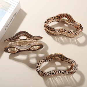 Close-up of leopard print acetate hair claws showing marble texture and metal spring detail