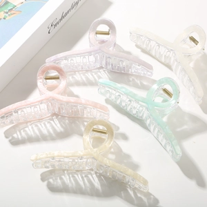 Close-up of five pearlescent wave hair claws in assorted pastel colors for elegant updos