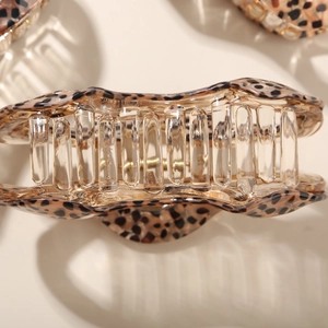 Close-up of leopard print acetate hair claw clip with glossy finish and smooth teeth