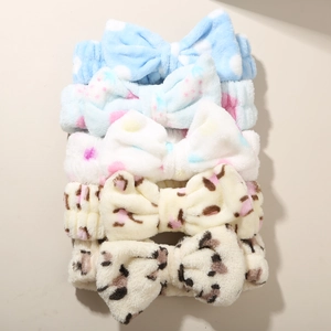 Close-up of soft leopard and polka dot plush bow headbands for washing face