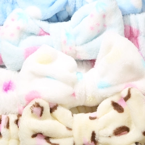 Detailed view of soft plush bow headbands in blue, white and leopard print colors