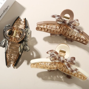 Three elegant acetate bow hair claws in brown and cream with classic plaid patterns