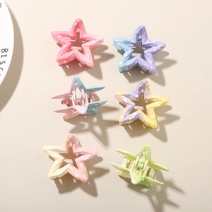 Detail view of six gradient star hair claws with matte finish and speckled texture