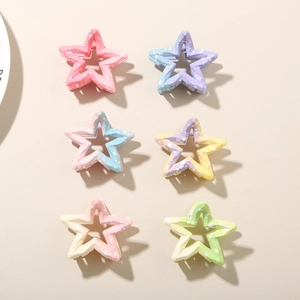 Detail showing six colorful star hair clips with matte finish and white ink splatter