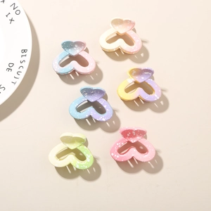 Detailed macro view of heart-shaped mini hair claws with macaron gradient colors and ink spots