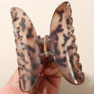 Detailaufnahme einer großen Haarspange mit Leopardenmuster und starker goldener Metallfeder
