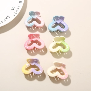 Close-up of 6 heart-shaped gradient macaron hair clips with white splatter pattern