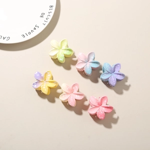 Detail view of 6-piece gradient plumeria flower hair claws with matte finish texture