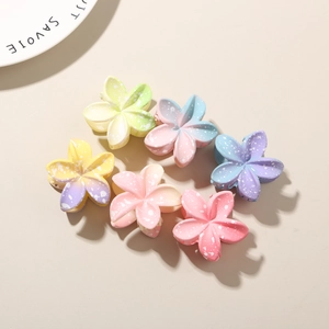 Close-up of macaron-colored plumeria flower hair claws with matte finish and gradient tones