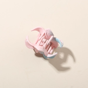 Detailed top view of a matte pink and blue marble pattern flower hair claw clip